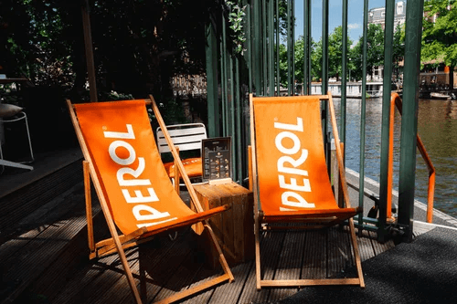 Aperol terrace chairs at Spritz Bar Amsterdam canal — Italian aperitivo at golden hour