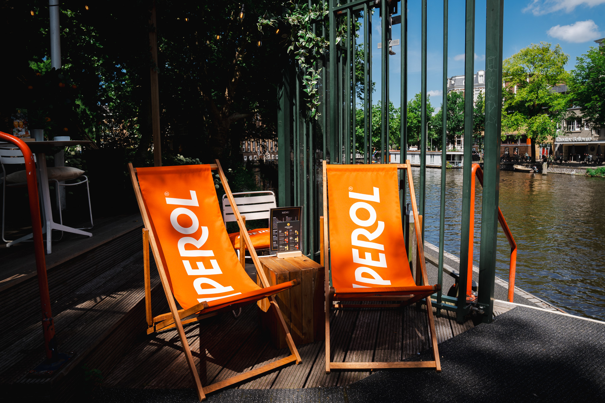 Aperol deck chairs on the waterside terrace with Amsterdam canal view