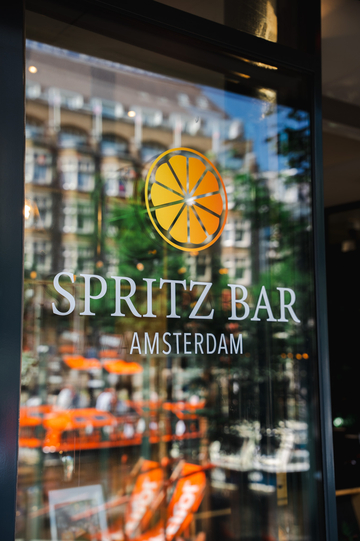 Spritz Bar Amsterdam logo on the glass entrance door